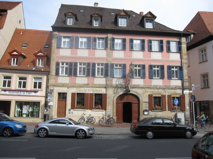 several old buildings next to each other near some parked cars