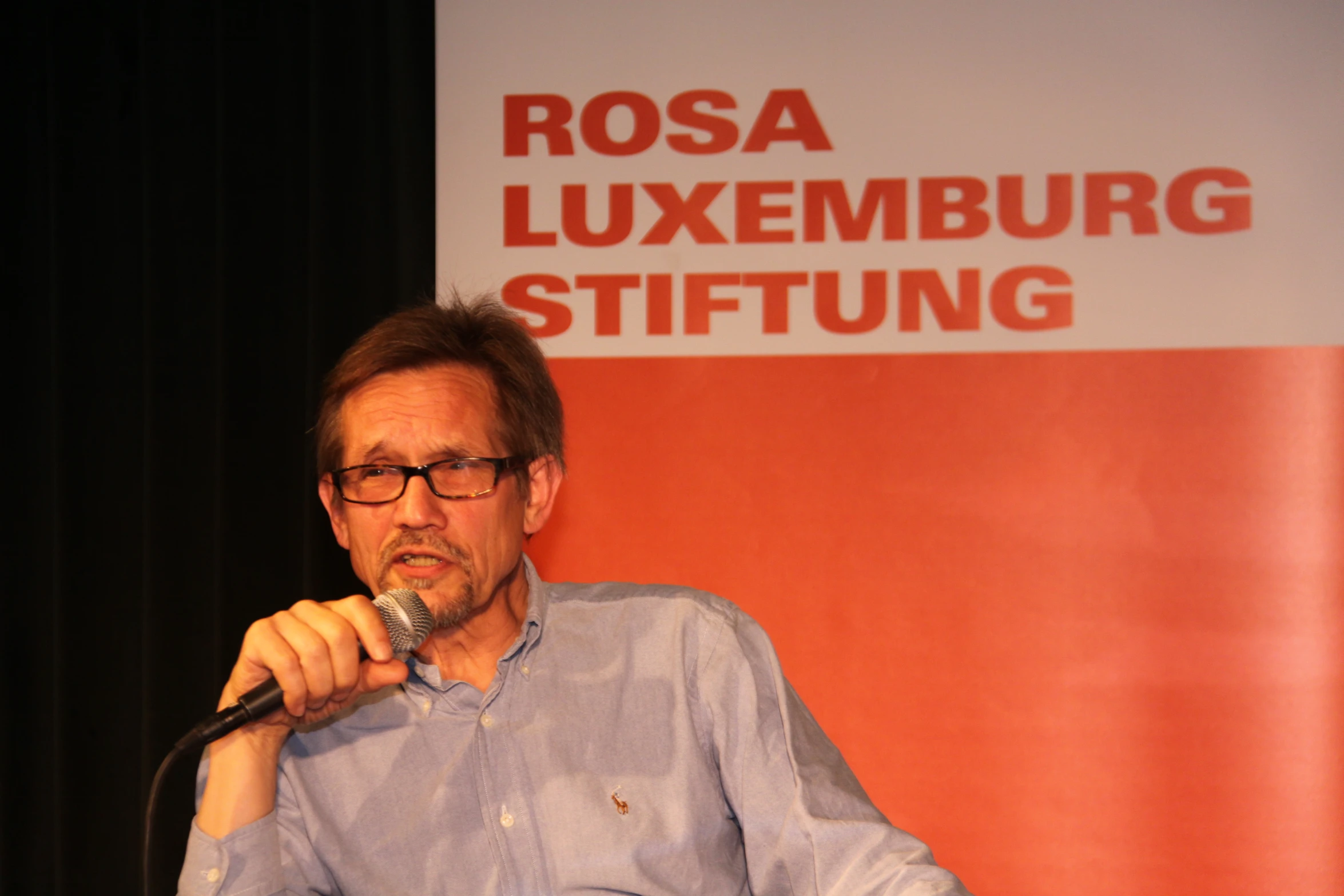 a man is holding a microphone and talking on a microphone