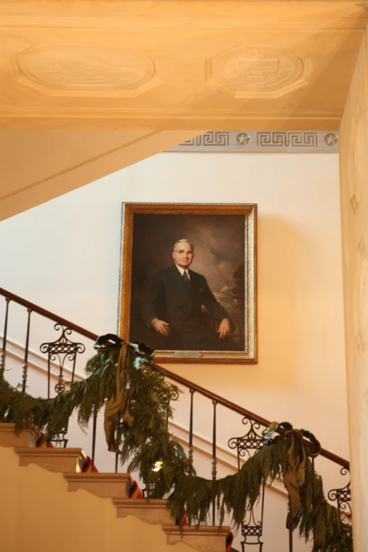 a painting hanging on a stair case in a house