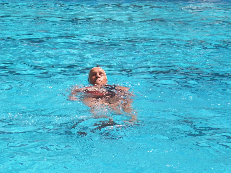 a woman is swimming in a pool looking up