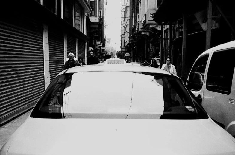 a white car parked in an alley next to a building