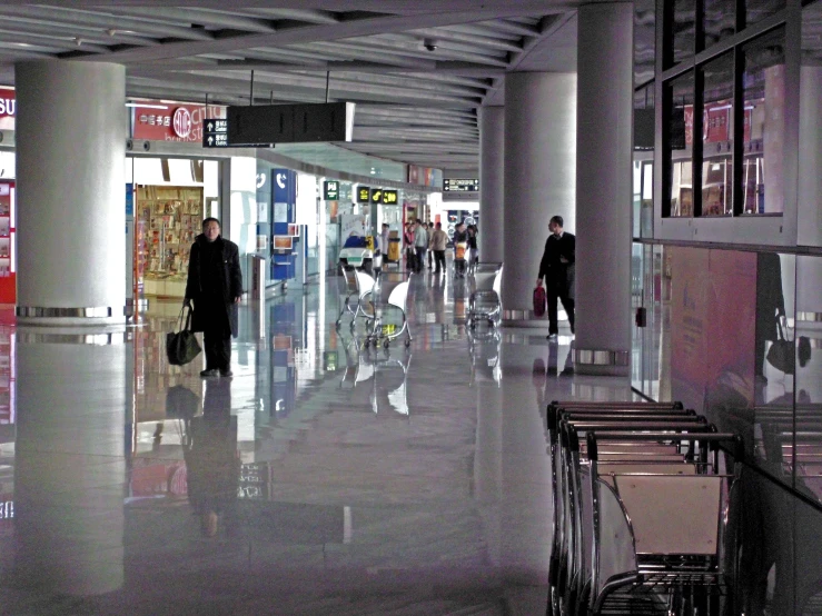 a group of people walk inside of an airport terminal