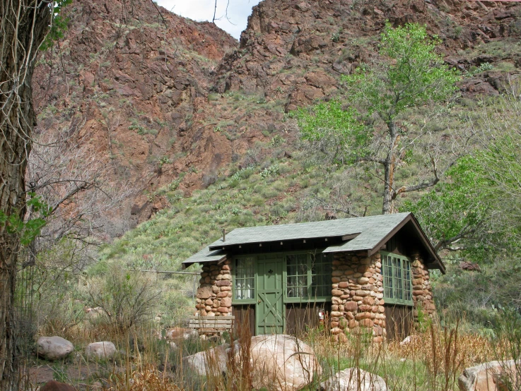 a log cabin set in the mountains next to some trees