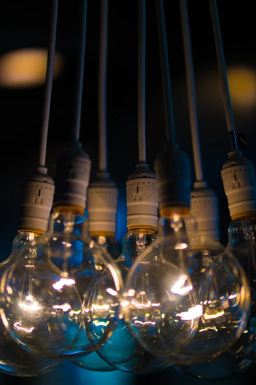 an array of light bulbs hanging from wires in the dark