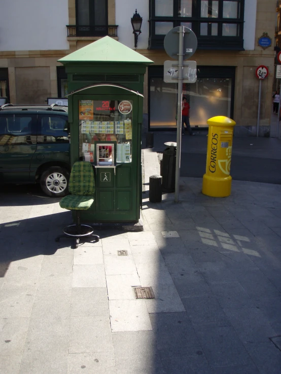 an old - fashioned phone booth on the street corner