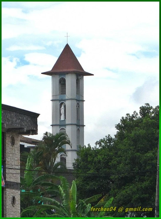 a white and brown clock tower in front of trees
