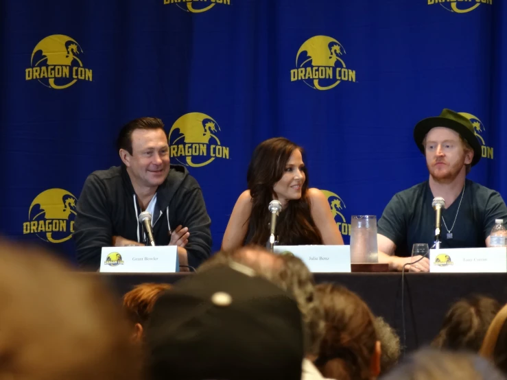 four people sit at a table with microphones in front of them