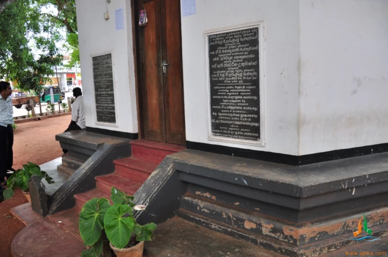 a person in black jacket standing on steps next to white building