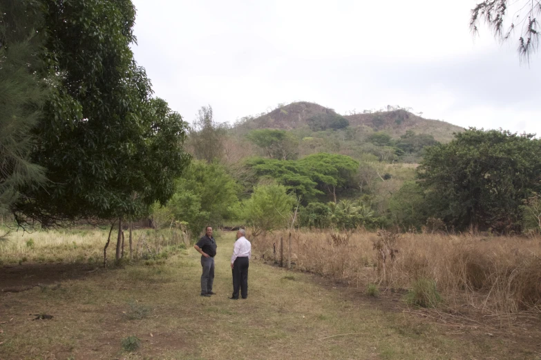 two men standing on a path in the woods