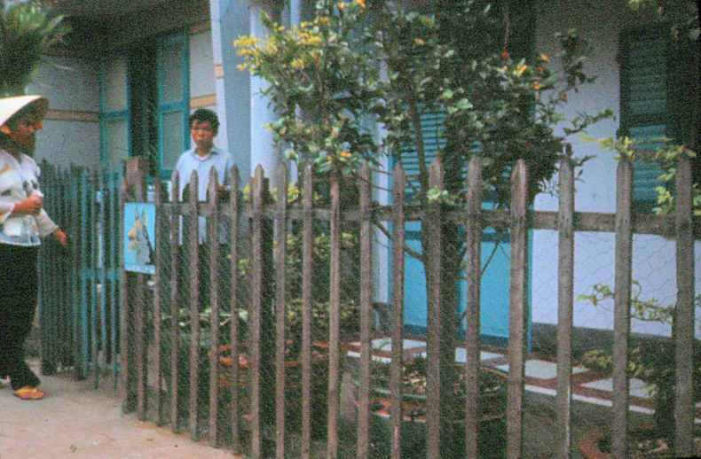 a woman holding a white umbrella standing next to a house