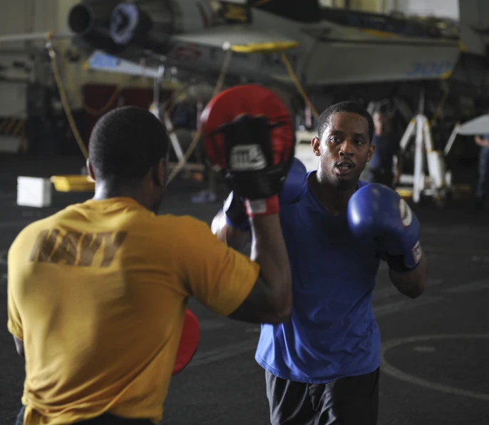 two men are fighting with a referee in the open