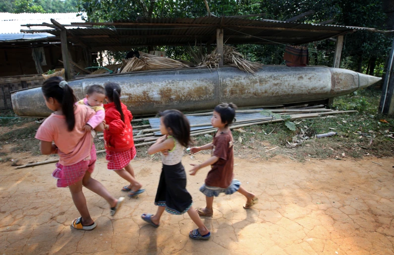 several s and boys walking with one holding the strings of an object