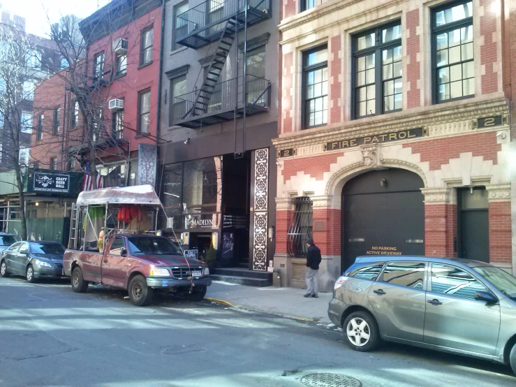 cars and buses are parked on the street in front of an old building