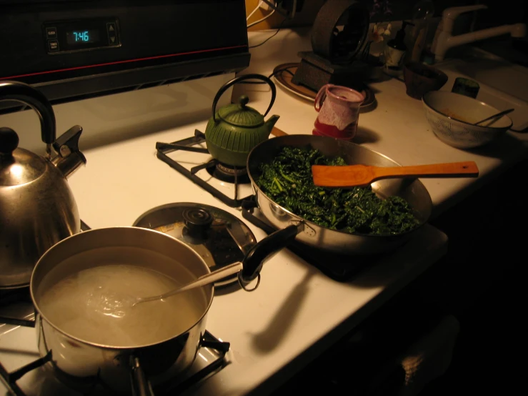 two pots sitting on top of a stove