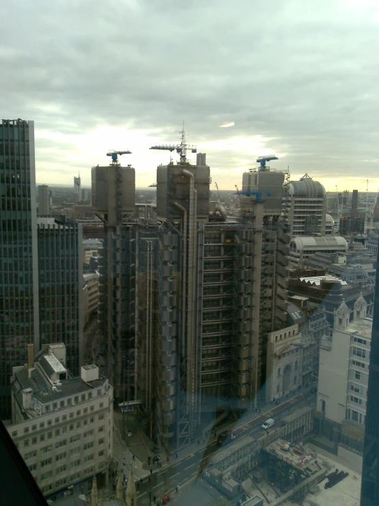 a city is seen through some buildings with cranes