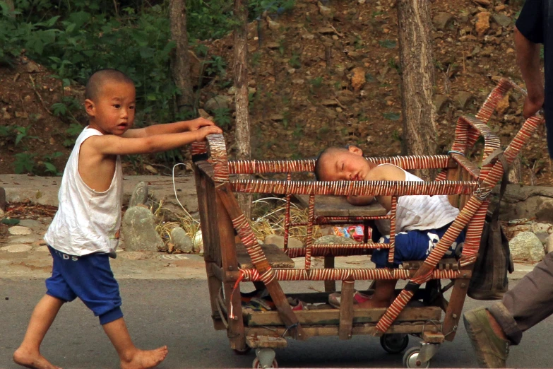 a man pulling a wooden cart full of children