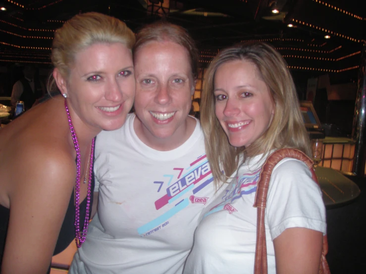 three women are posing for the camera in a bar