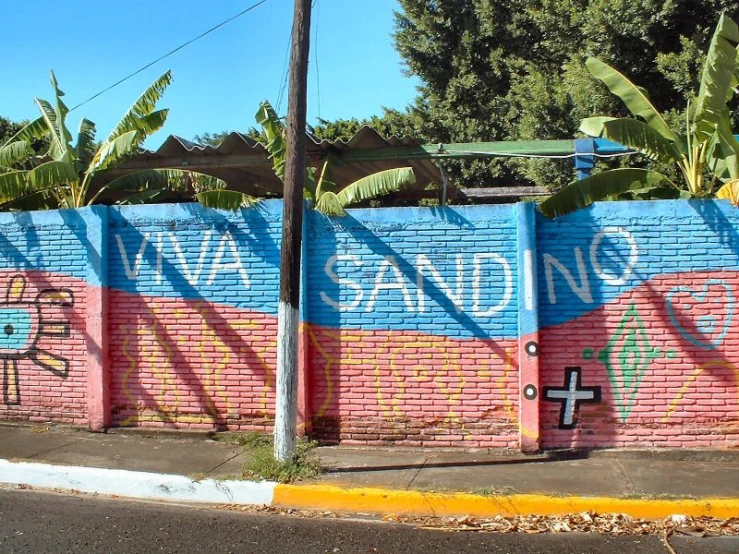 a wall is painted bright blue and pink with a cross