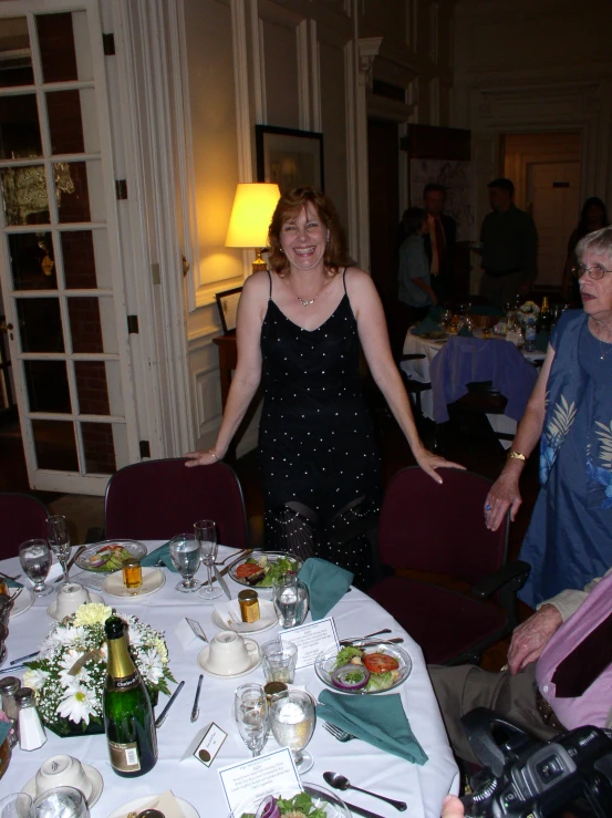 woman in dress posing for a po near a table full of food