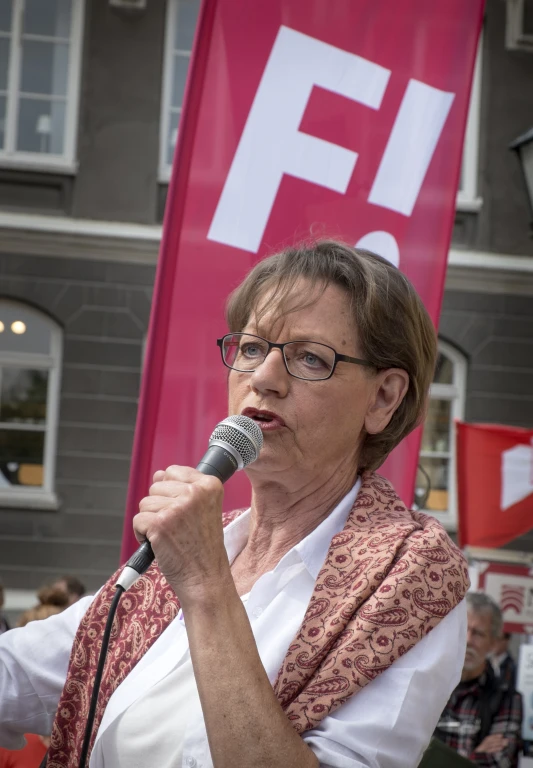 woman holding a microphone speaking into a mic