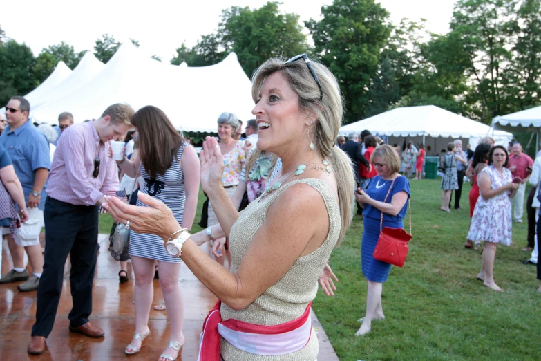 woman in short dress talking with a group of people