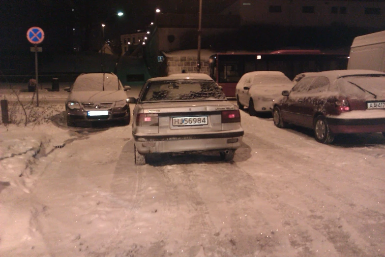 cars sitting in the snow on the street