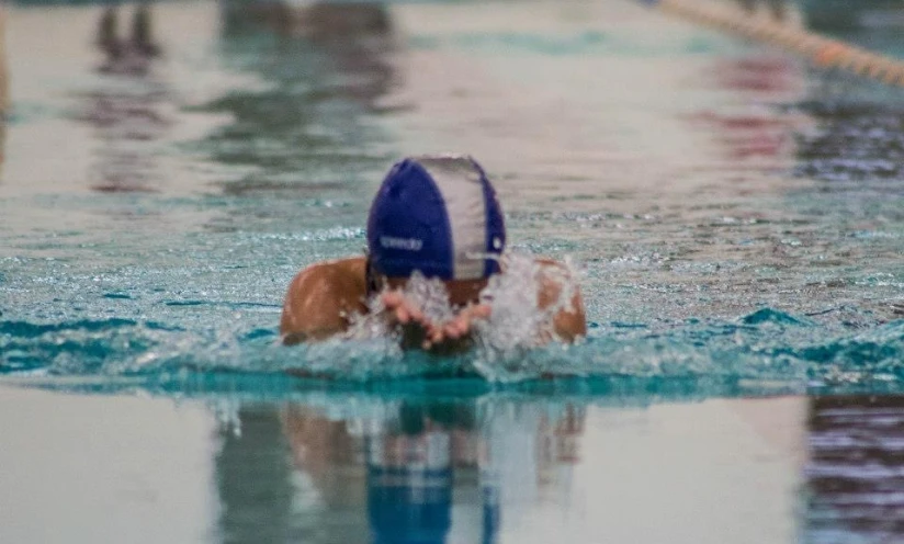 a swimming swimmer wearing a blue and white cap