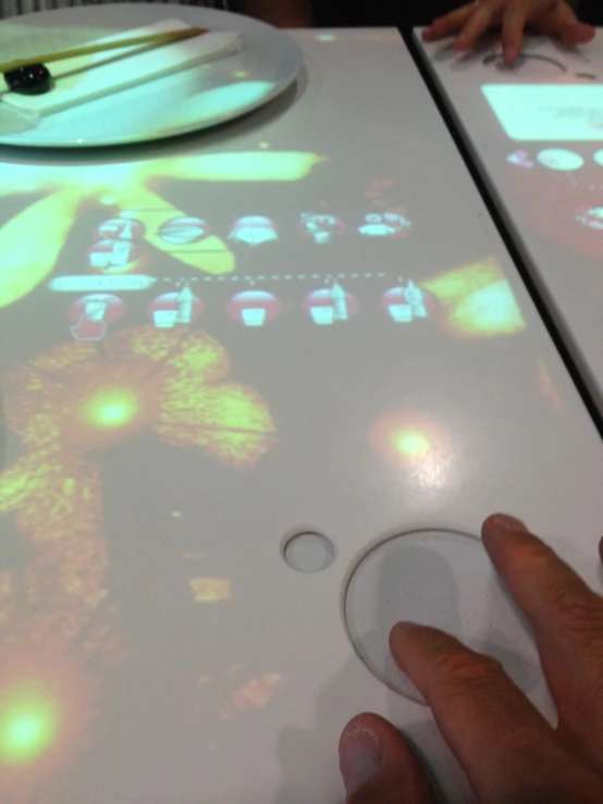 a person using projected light to build soing on a tabletop