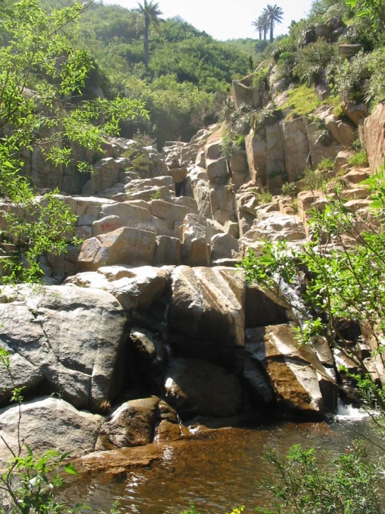 there is a waterfall surrounded by large rocks