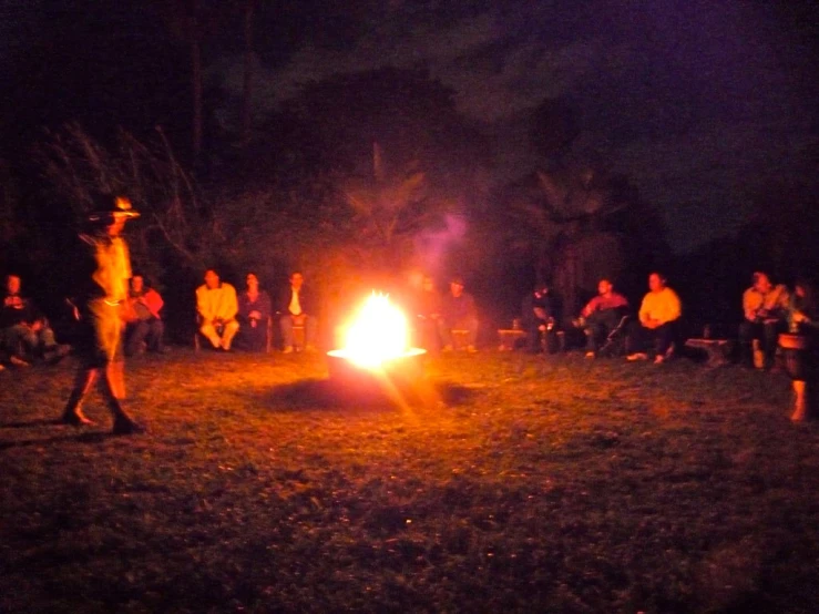 people sitting at a campfire and talking