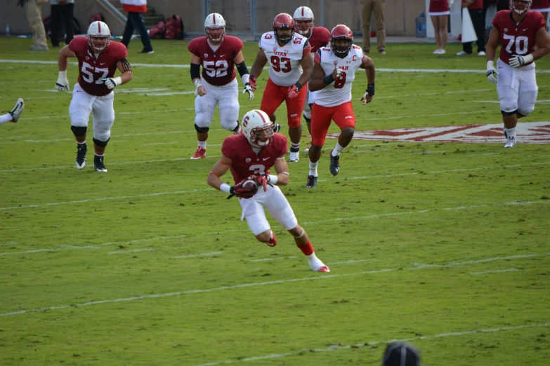 several college football players running across a field