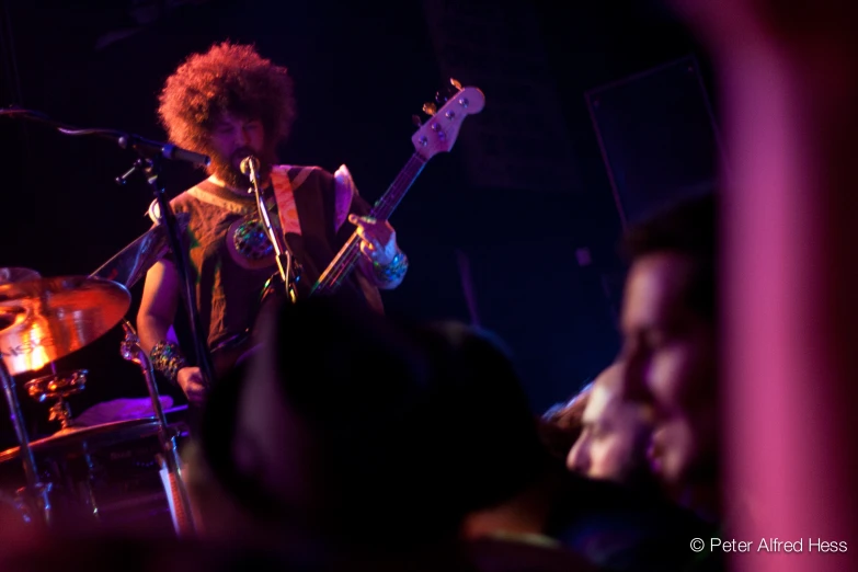 some people and a man and guitar on stage