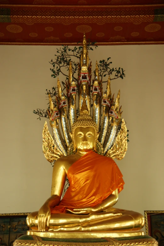 there is a gold buddha statue next to a wall