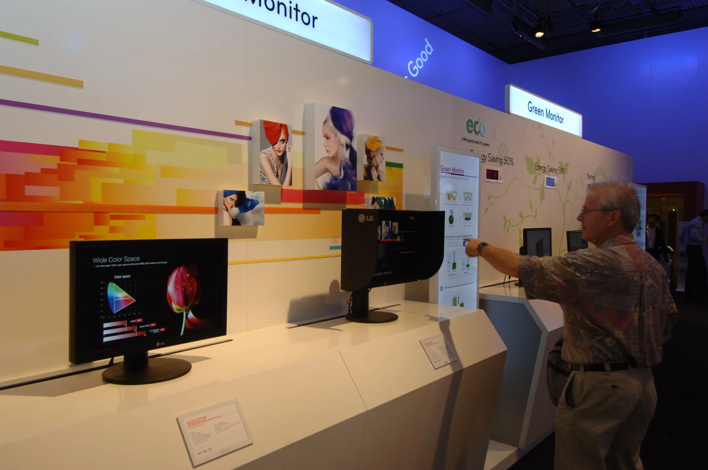 a man with gray hair standing in front of computer monitors