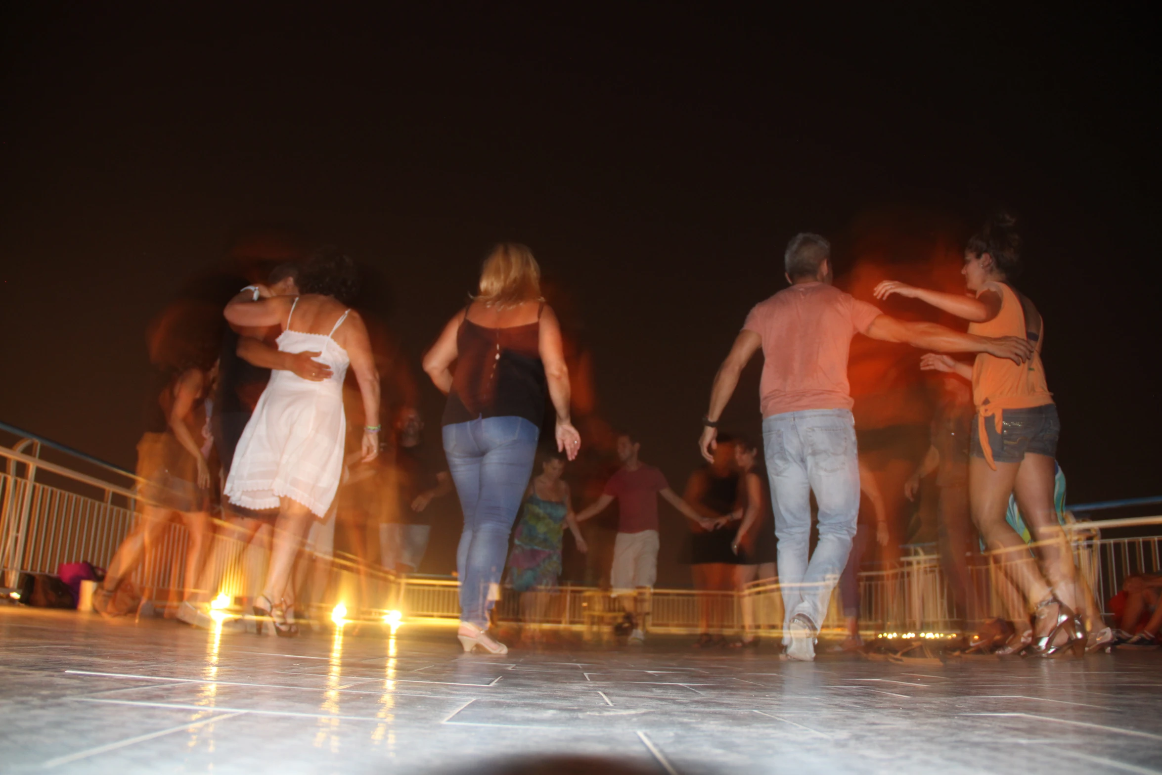 people standing around and dancing on the street