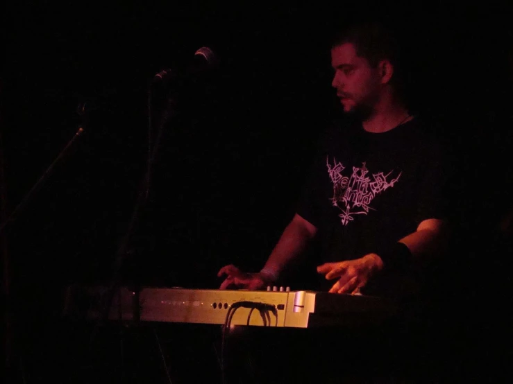 a man is playing the keyboard and playing it on a stage