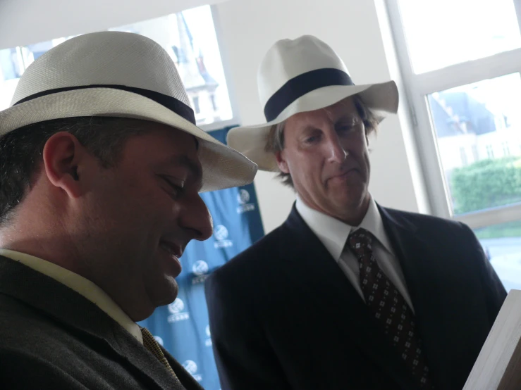 two men wearing hats in a room
