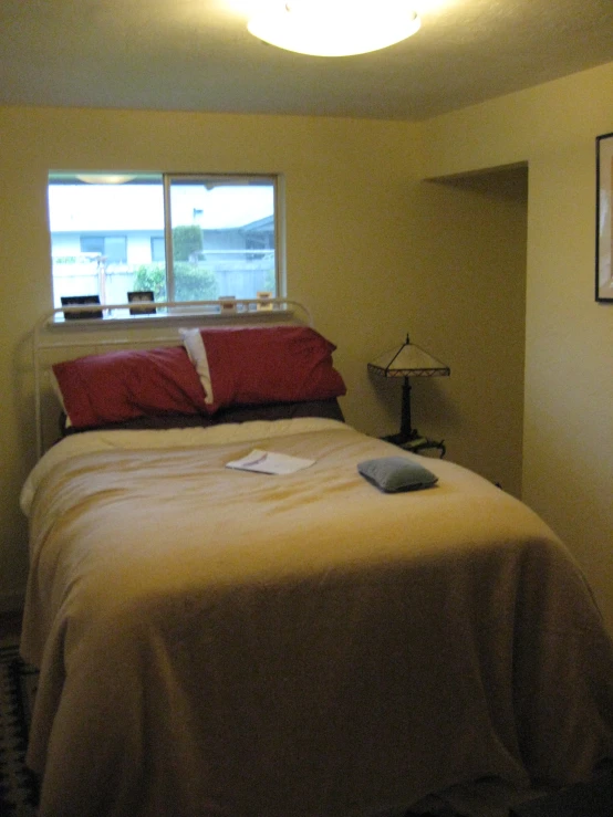 there is a bedroom with a bed, nightstand and window