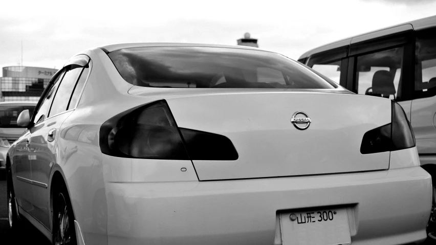 a rear view of a white car with other cars in the background
