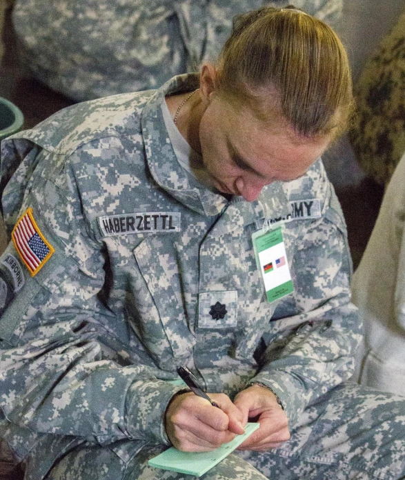 female army personnel writing on a notepad