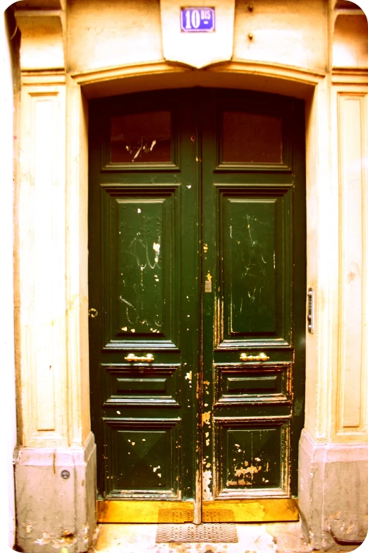 a couple of green doors on a yellow building