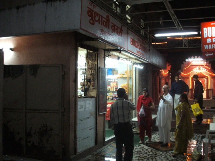 group of people walking in an alley at night