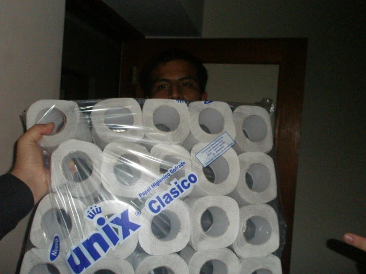 a man holding a large bunch of toilet paper