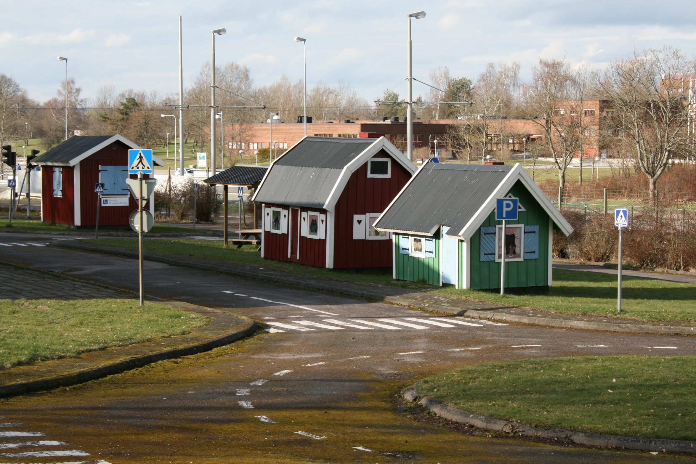 the three houses are all colorful and the one in green has black windows