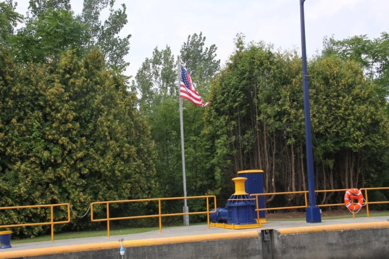 a flag flies at the end of an industrial bridge