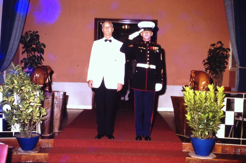 a man standing next to another man in uniform