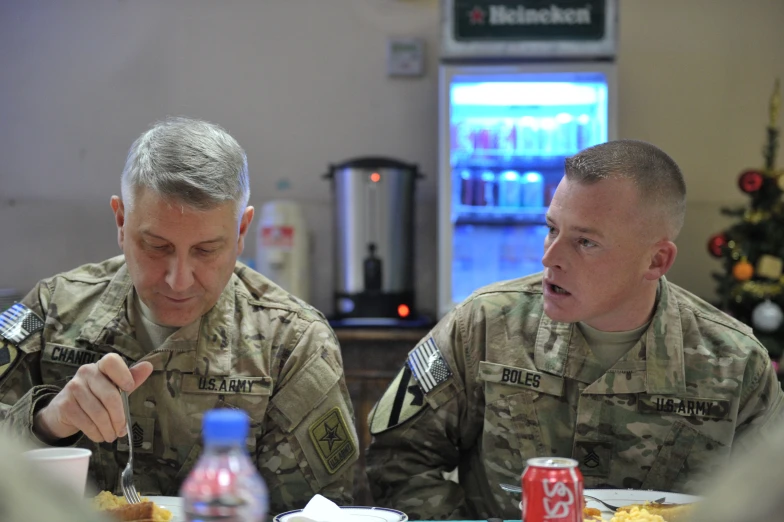 two soldiers are sitting down to a meal