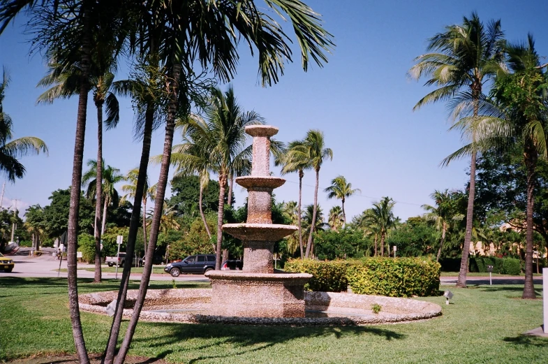 a statue of a water fountain surrounded by palm trees