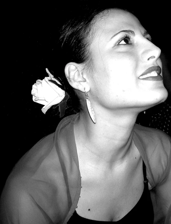 black and white image of woman smiling and holding flower