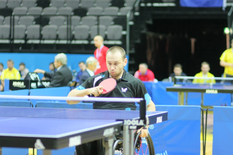 a man holds a paddle next to a table